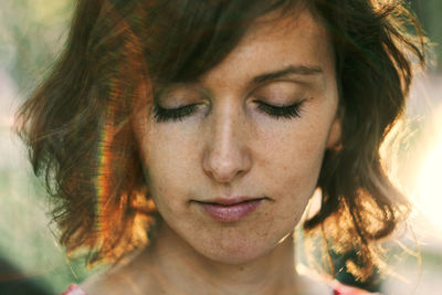 Close-up portrait of young woman with eyes closed