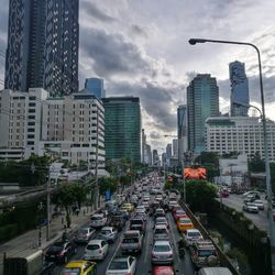 Traffic on city street amidst buildings against sky