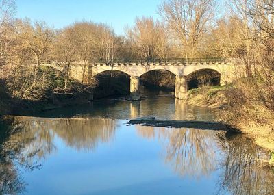 Arch bridge over river against sky