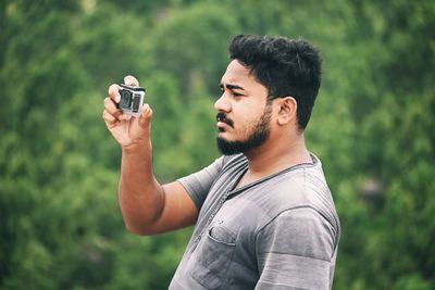 Portrait of young man holding camera