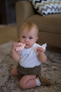 Little baby girl sitting on the floor of the living room