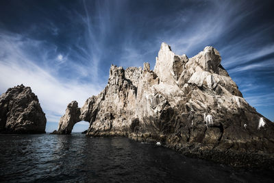 Rock formations by sea against sky