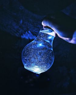 Close-up of hand holding light bulb