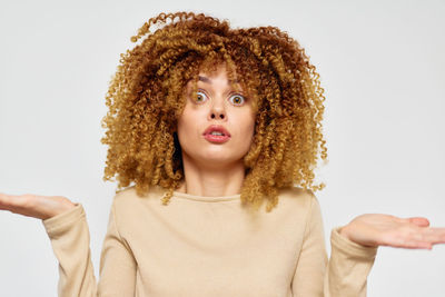 Portrait of smiling young woman against white background