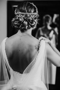 Rear view of bride getting dressed