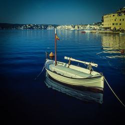 Boats moored at harbor against sky