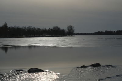 Scenic view of lake against sky during winter