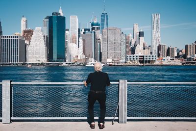 Woman standing on bridge over sea