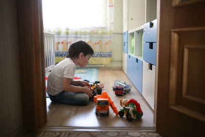 Child boy playing alone in the room, loneliness and sadness