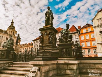 Low angle view of statue against buildings in city