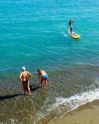 Rear view of friends enjoying in sea