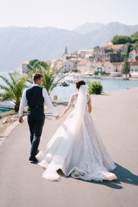 Rear view of woman with umbrella on shore