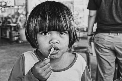 Portrait of girl putting spoon in mouth