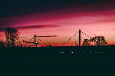 Silhouette bridge against sky at sunset