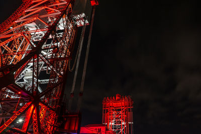 Low angle view of illuminated ferris wheel against sky at night