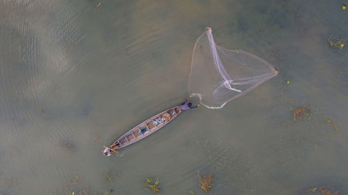 High angle view of fisherman throwing net at river