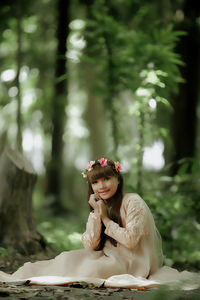 Portrait of woman sitting on plant