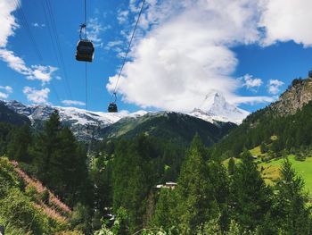 Low angle view of ski lift over mountains against sky