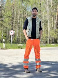 Portrait of young man standing on road