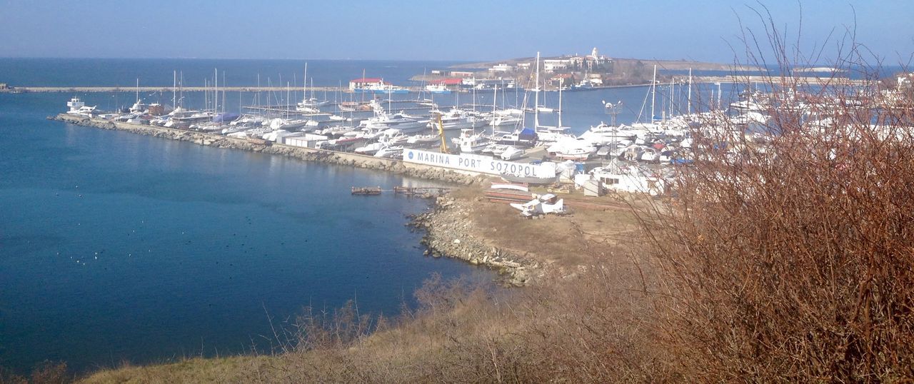 water, sea, building exterior, architecture, built structure, high angle view, harbor, city, blue, waterfront, reflection, nautical vessel, cityscape, sky, coastline, outdoors, beach, nature, day, no people