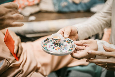 Midsection of people holding coffee cup