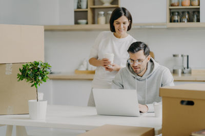 Couple with cardboard boxes at new home