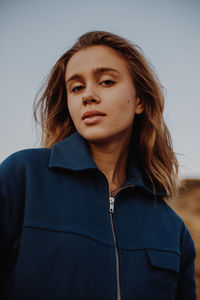 Portrait of beautiful woman standing against clear sky