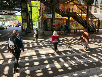 People walking on road along buildings