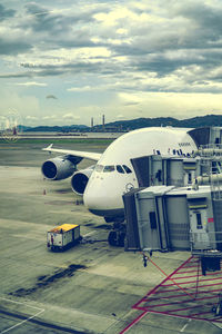 Airplane on airport runway against sky