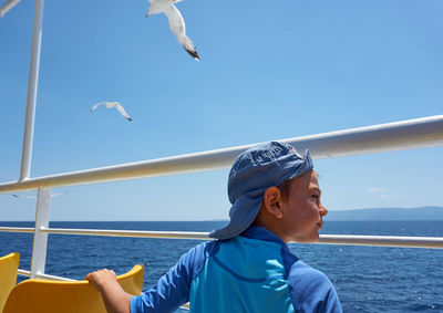 Young woman jumping in sea against blue sky