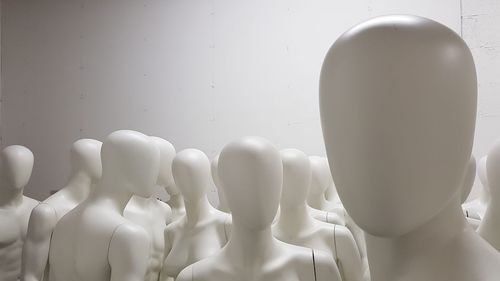 Close-up of mannequins against wall