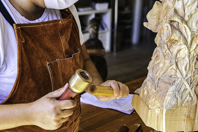 Sculptress with mask carving wooden figure