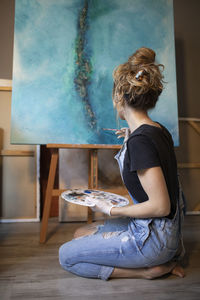 Young woman painting in her atelier