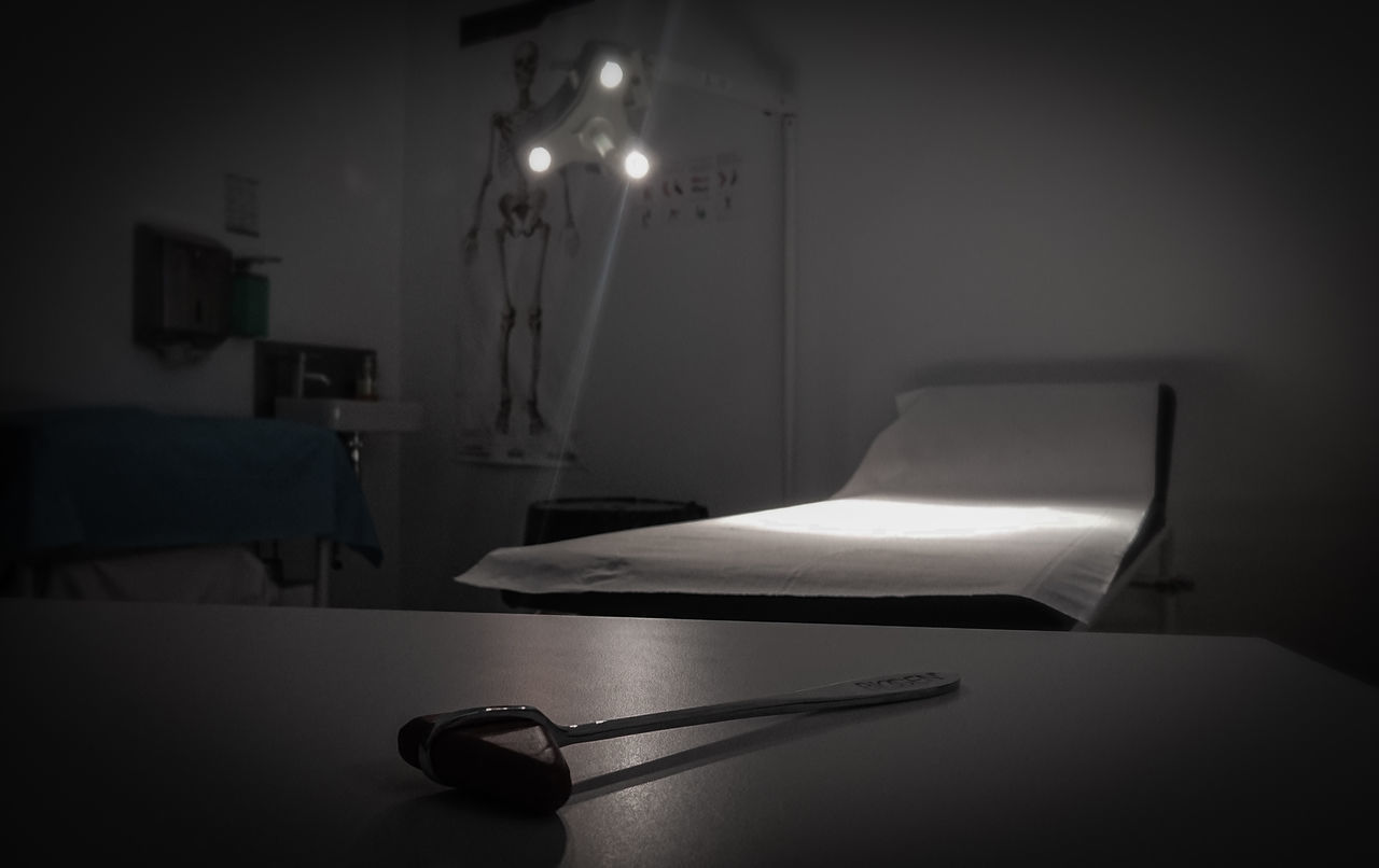 ILLUMINATED ELECTRIC LAMP ON TABLE BY BED