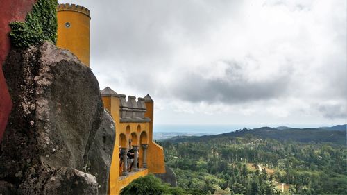 Buildings against mountain range against sky