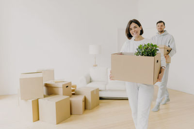 Smiling couple with cardboard boxes at new home