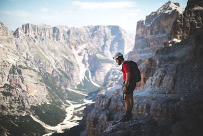 Man standing on cliff against mountains