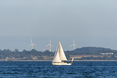 Sailboat sailing in sea against sky