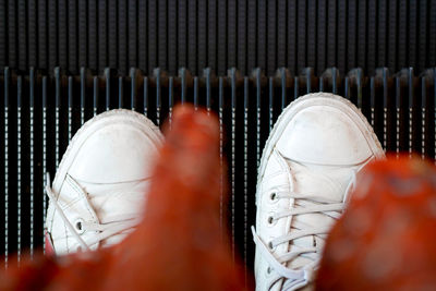 Low section of man wearing white shoes over metal floor