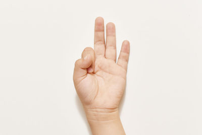 Cropped image of person showing ok sign against white background
