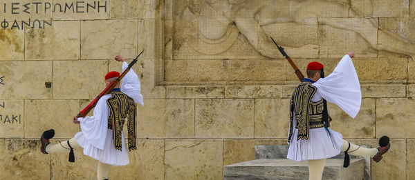 Rear view of men standing against wall