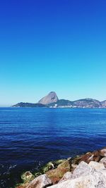 Scenic view of sea against clear blue sky