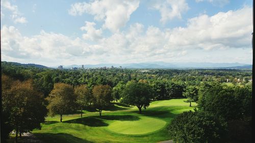 Scenic view of golf course against sky