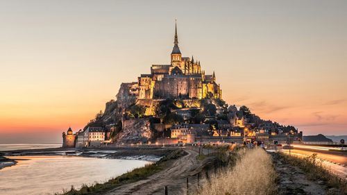 Built structures against sky at sunset
