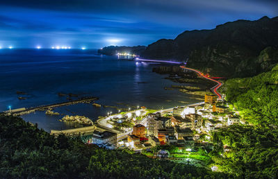 High angle view of illuminated bay against sky at night