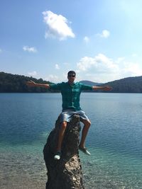 Portrait of man standing in lake against sky