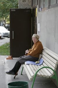 Side view of woman sitting on bench