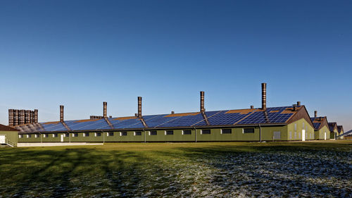 View of built structures against clear blue sky