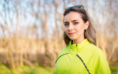 Young woman with neon green jacket looking at camera
