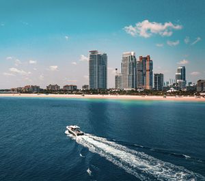 Scenic view of sea by buildings against sky